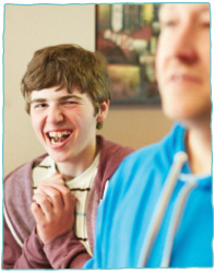 Young care client laughing with care staff
